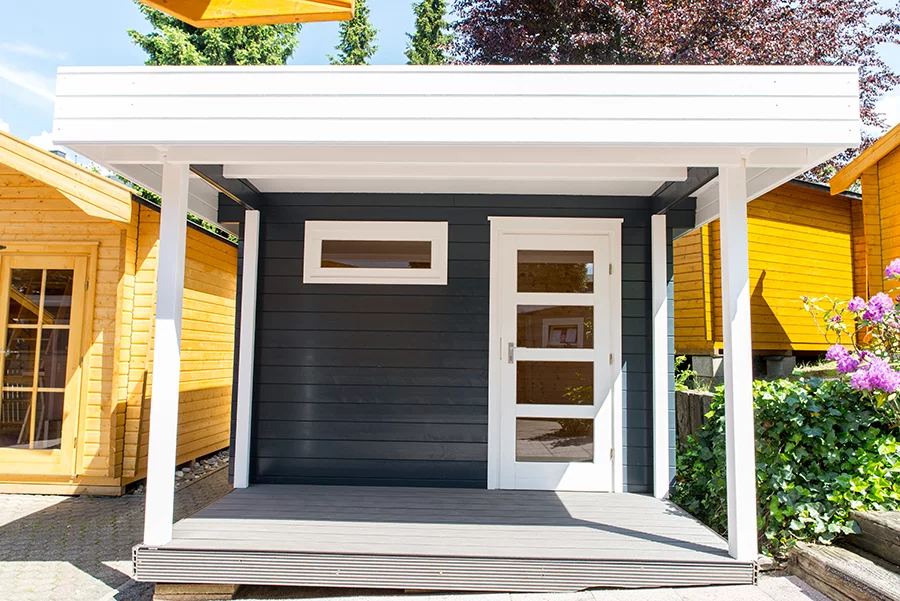 Holz Gartenhaus mit überdachter Terrasse, verglaster Tür und feststehenden Lichtband an der Front