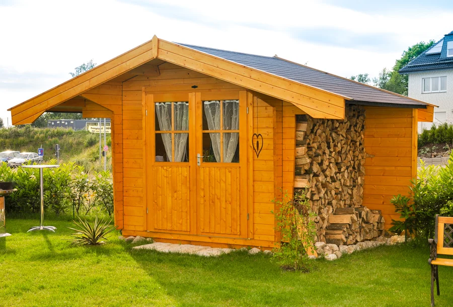 Holz Gartenhaus mit Satteldach und verglaster Doppeltür. Ansicht schräg von der Seite